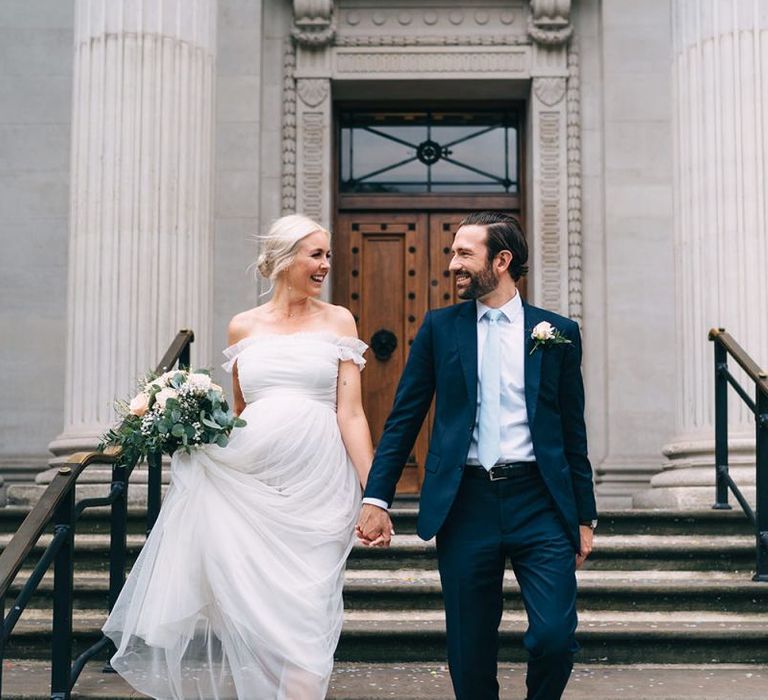 Pregnant bride in maternity wedding dress walking down the steps at Old Marylebone Town Hall