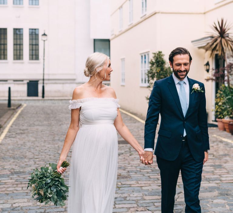 Bride and groom portrait in London with bride in maternity wedding dress