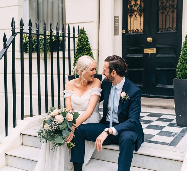 Bride and groom sitting on steps in London