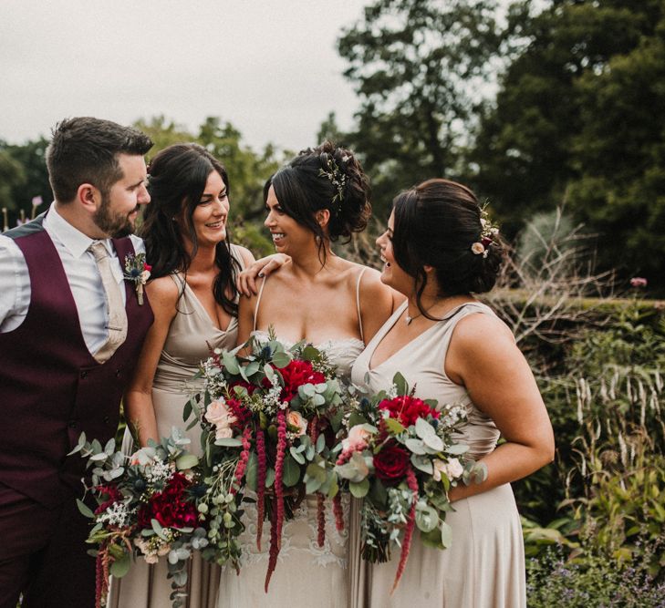 Wedding Party In Pale Grey Dresses With Red Bouquets // Glamorous Iscoyd Park Wedding With Burgundy, Navy And Ivory Colour Scheme With Artistic And Alternative Images From Carla Blain Photography