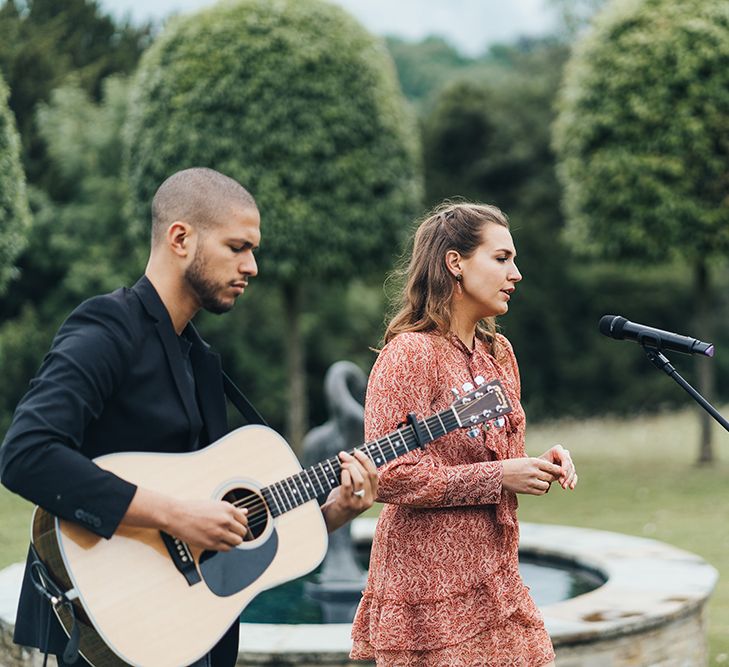 Guitarist and Vocalist Performing at the Outdoor Wedding Ceremony