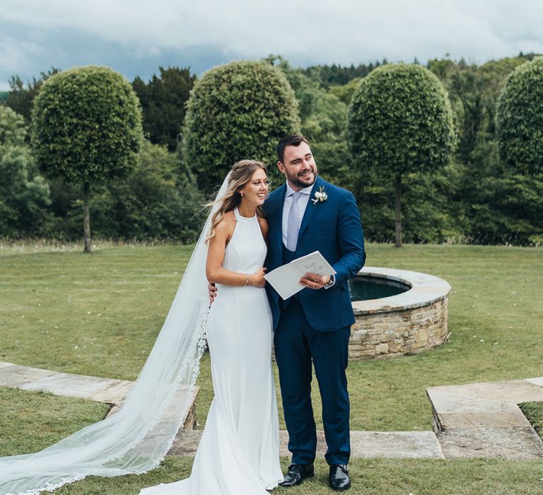 Bride in Halterneck Wedding Dress and Groom in Navy Suit Just Married