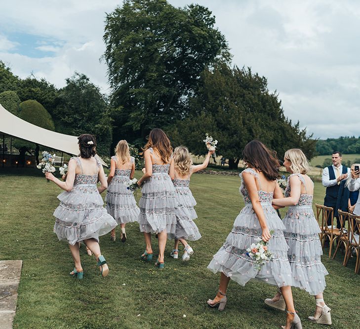 Bridesmaids in Embroidered Tulle Needle and Thread Dresses Walking Toward the Stretch Tent Marquee Reception