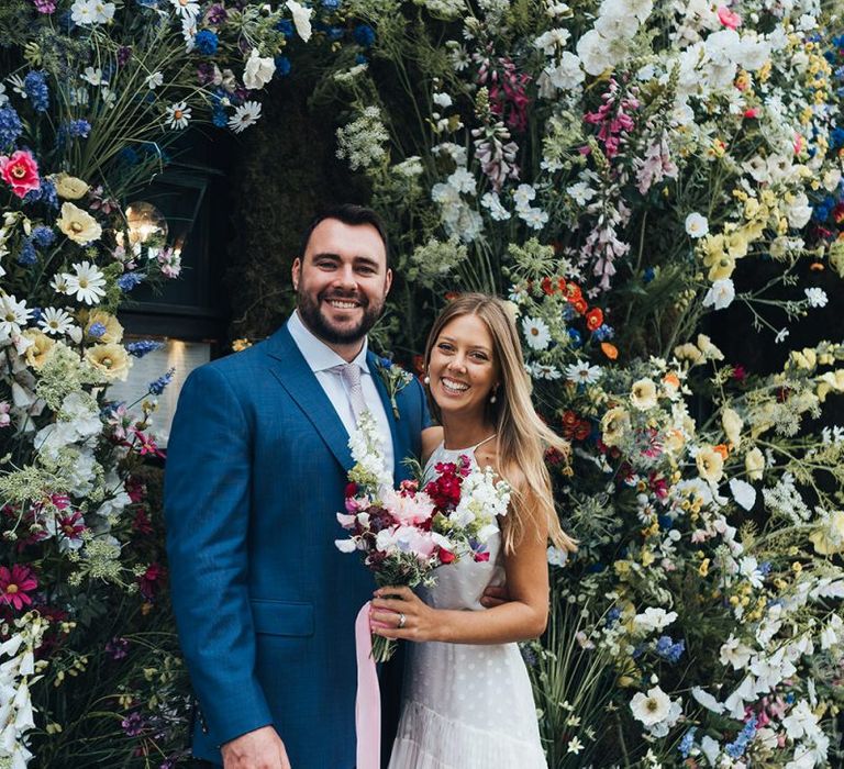 Bride and Groom Smile With Flowers