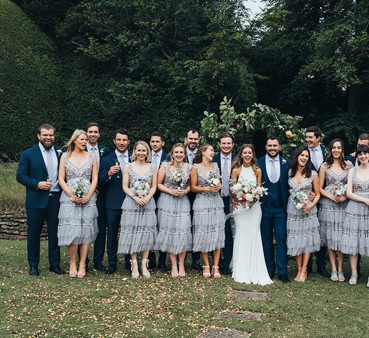 Wedding Party Portrait with Bridesmaids in Needle and Thread Dresses and Groomsmen in Navy Blue Suits by Miss Gen