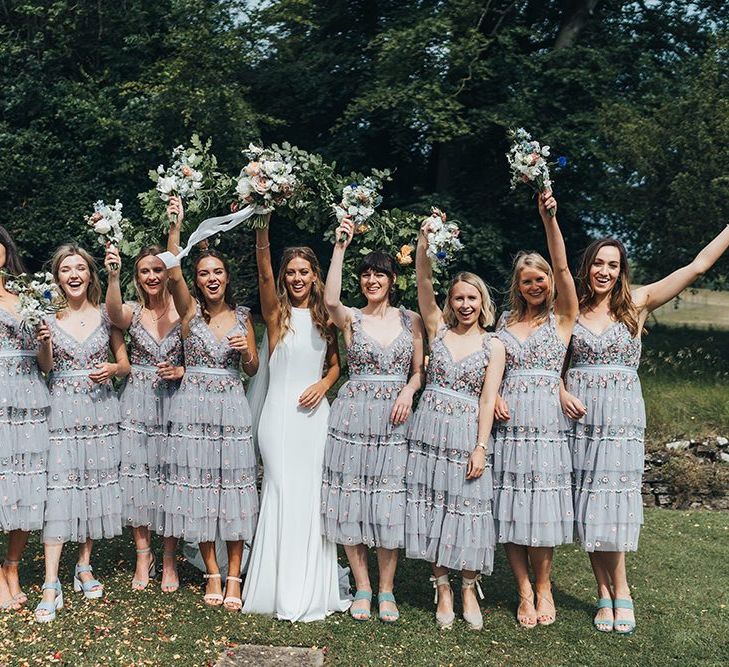 Bridal Party Portrait with Bridesmaids in Needle and Thread Dresses and Bride in Made With Love Wedding Dress Waving Their Bouquets in the Air