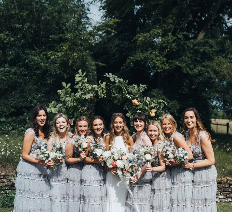 Bridal Party Portrait with Bridesmaids in Needle and Thread Dresses and Bride in Made With Love Wedding Dress Holding Bright Bouquets