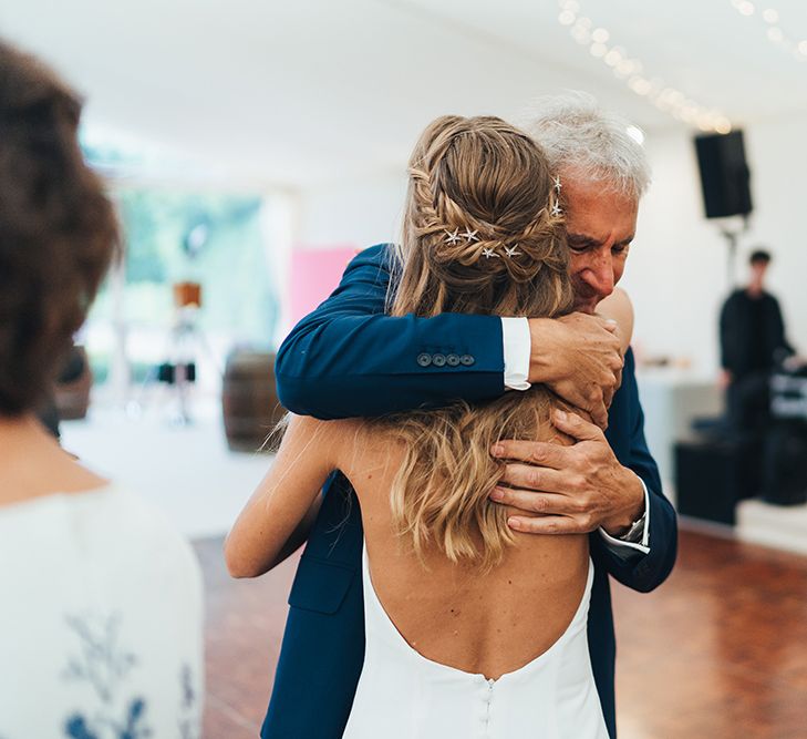 Father of the Bride cuddling His Daughter with Half up Half Down Braided Hair Accessorised with Tilly Thomas Lux Hair Slides