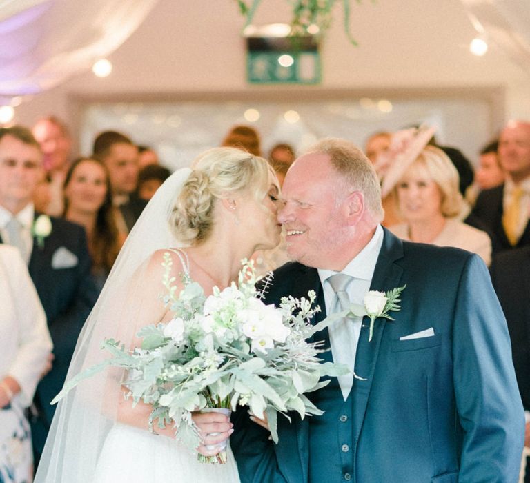 Bride in Lace Wedding Dress Kissing the Father of The Groom as She Walks Up the Groom