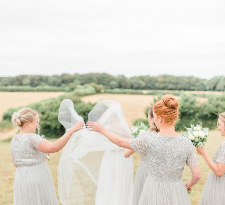 Bridesmaids in Grey Sequin &amp; Tulle Dresses Adjusting The Brides Wedding Veil