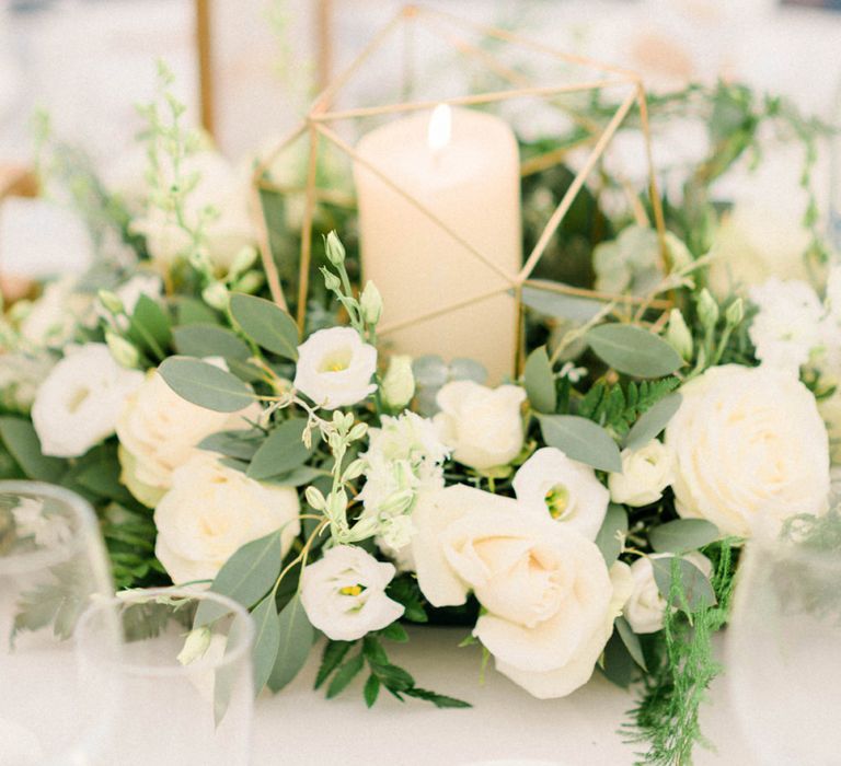 Table Centrepiece with White and Green Flowers, Church Candles and Gold Geometric Decor