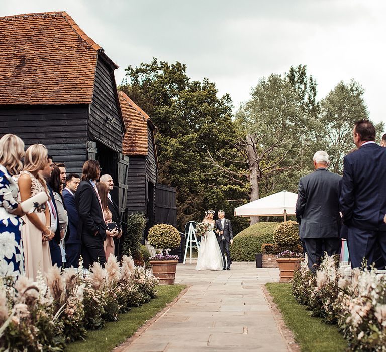 Barn Wedding With Bride Walking Down The Aisle