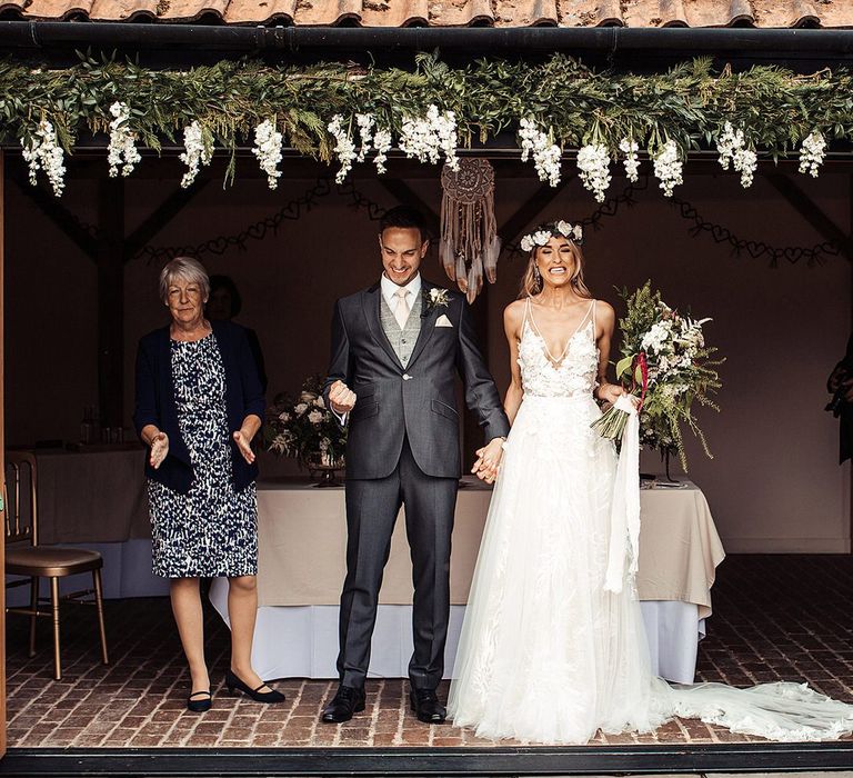 Bride and Groom During Outdoor Ceremony With Flower Decor and Dream Catchers