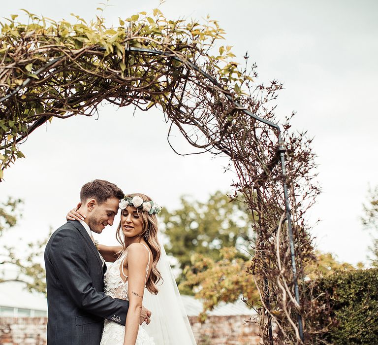 Bride and Groom at Barn Wedding Under Flower Arch