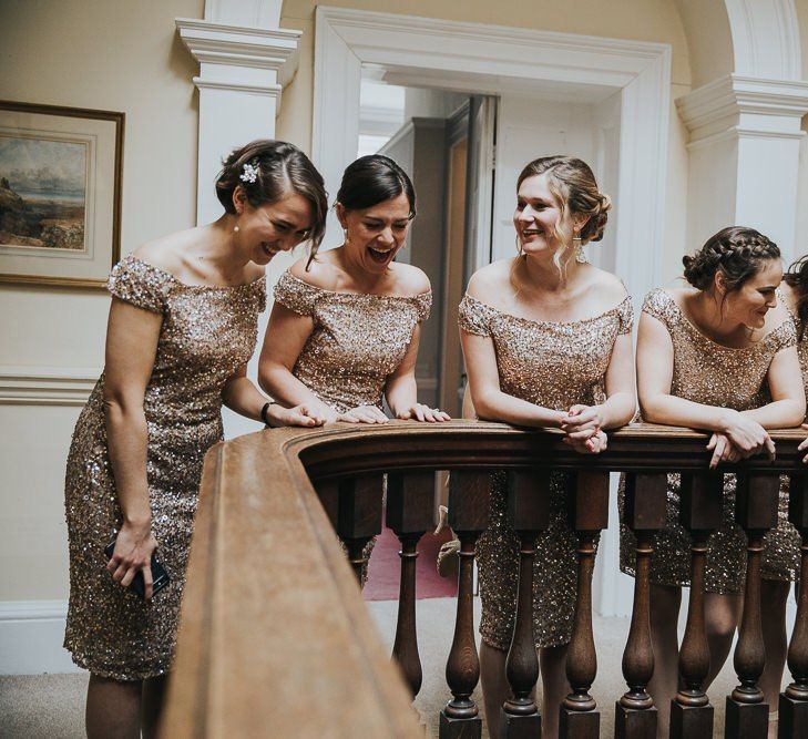 Bridesmaids in Gold Dresses Peer Over Staircase