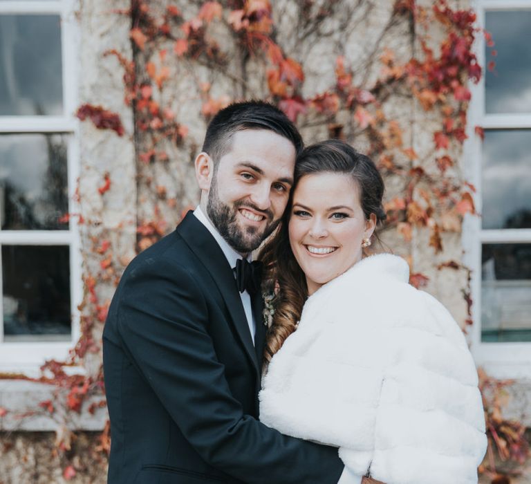 Groom Wears Tux and Bride Wears Faux Fur Cover Up For Winter Wedding at Kirtlington Park Wedding Venue