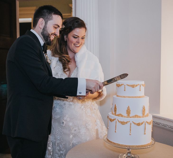 Bride and Groom Cut The Cake with Gold Detail