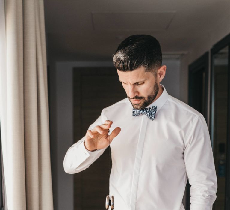 Groom in Navy Trousers, White Skirt and Floral Bow Tie