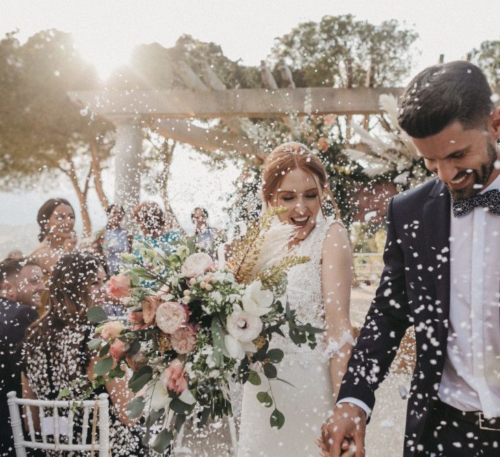 Confetti Moment with Groom in Tuxedo and Bride in Pronovias Wedding Dress