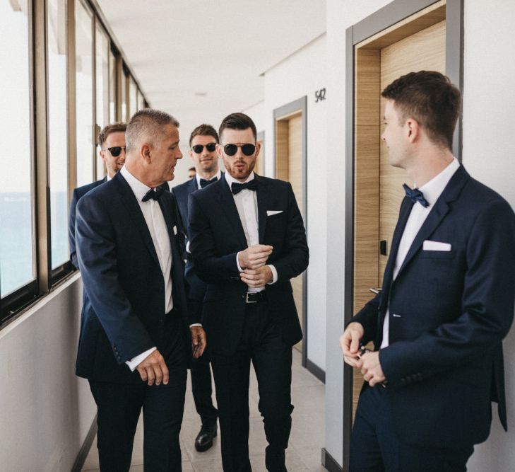 Stylish Groomsmen in Navy Suits with Bow Ties and Sunglasses