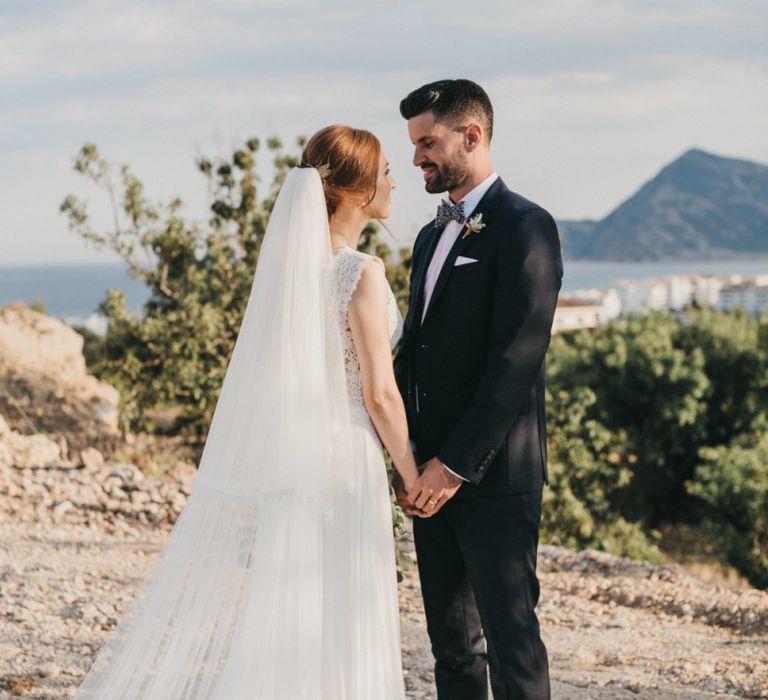 Bride and Groom Holding Hands on a Spanish Cliffside