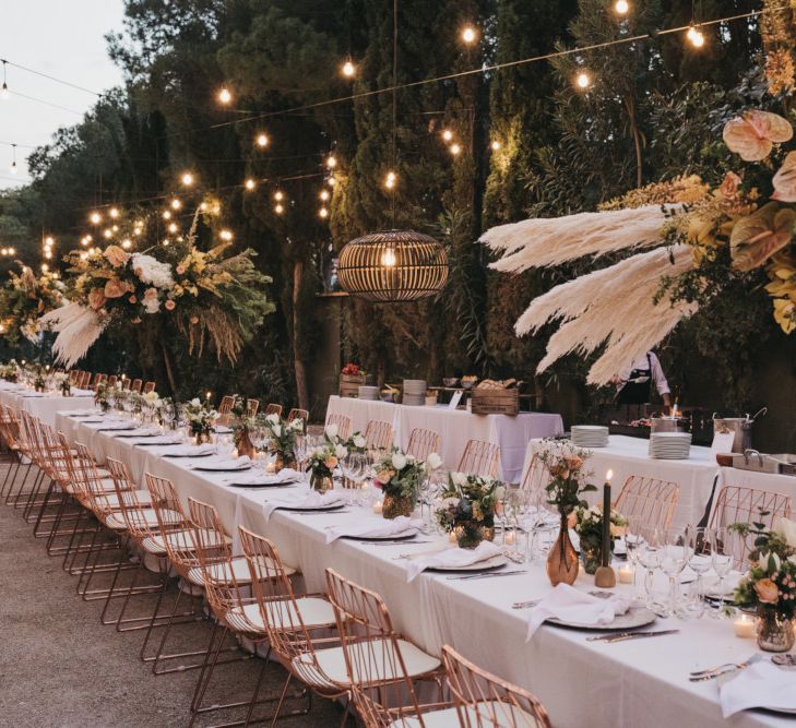 Outdoor Wedding Reception Decor with Festoon lights, Hanging Installation, Copper Vases and Chairs