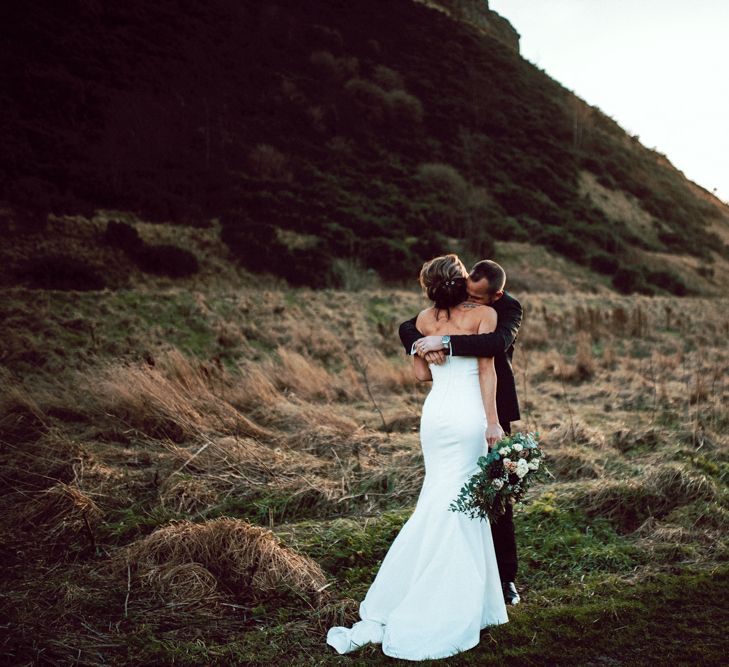 Groom embracing his bride at Winter wedding