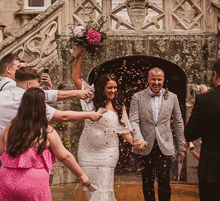 Confetti Moment with Bride in Grace Loves Lace Wedding Dress and Groom in Grey Blazer and Bow Time