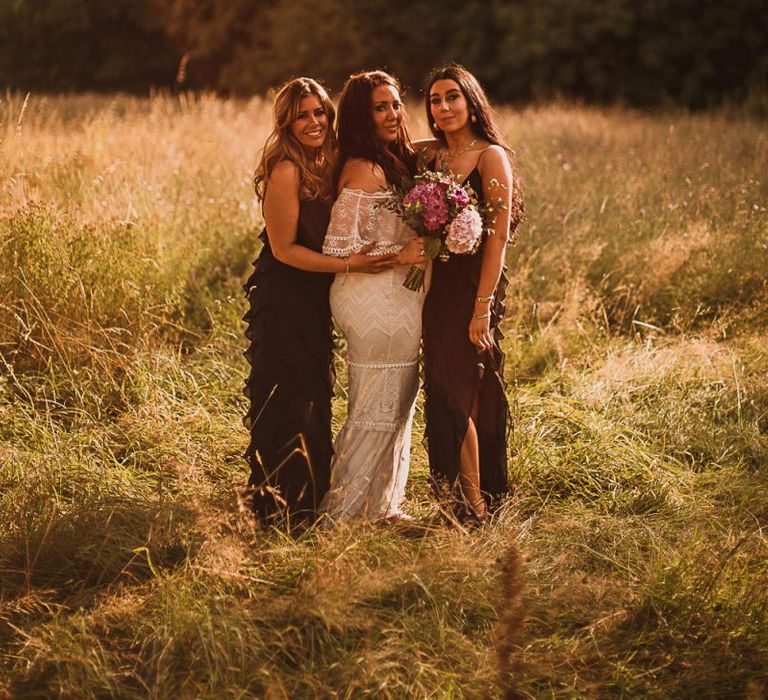 Bridal Party Portrait with Bride in Emanuela Grace Loves Lace Wedding Dress and Bridesmaids in Black Dresses