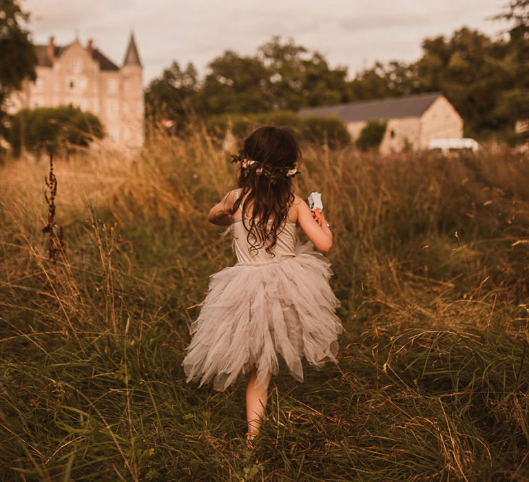 Flower Girl in Grey Tulle Tutu Running Through a Field