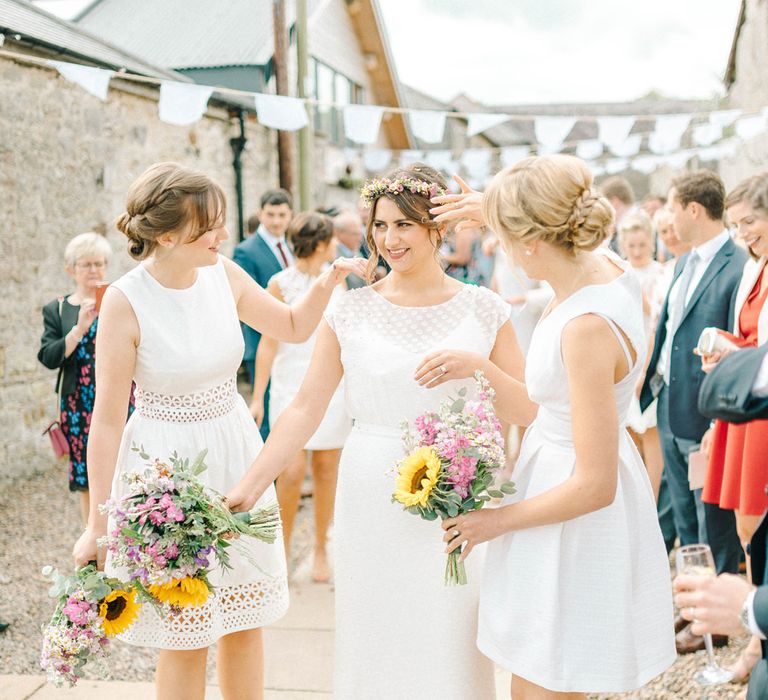 Bride in Chiffon Polka Dot Dress by Kate Halfpenny | Bridal Flower Crown | Bridesmaids in Mismatched Knee-Length White Dresses | Bright Bouquets with Sunflowers | Bridal Plaited Up Do | White Bunting | Colourful Paper Cranes &amp; Sunflower Wedding Décor in Rustic Barn | Sarah-Jane Ethan Photography