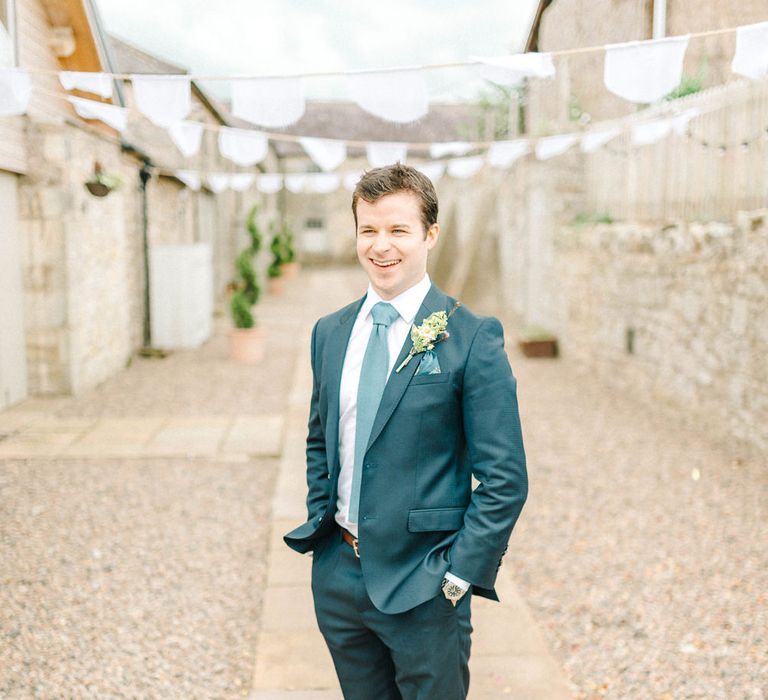 Groom in Blue Hugo Boss Suit with Dusty Blue Tie | White Bunting | Colourful Paper Cranes &amp; Sunflower Wedding Décor in Rustic Barn | Sarah-Jane Ethan Photography