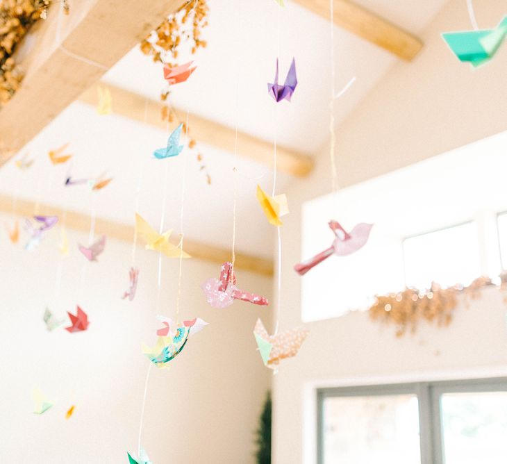 Paper Cranes Hanging from Barn Beams | Colourful Paper Cranes &amp; Sunflower Wedding Décor in Rustic Barn | Sarah-Jane Ethan Photography