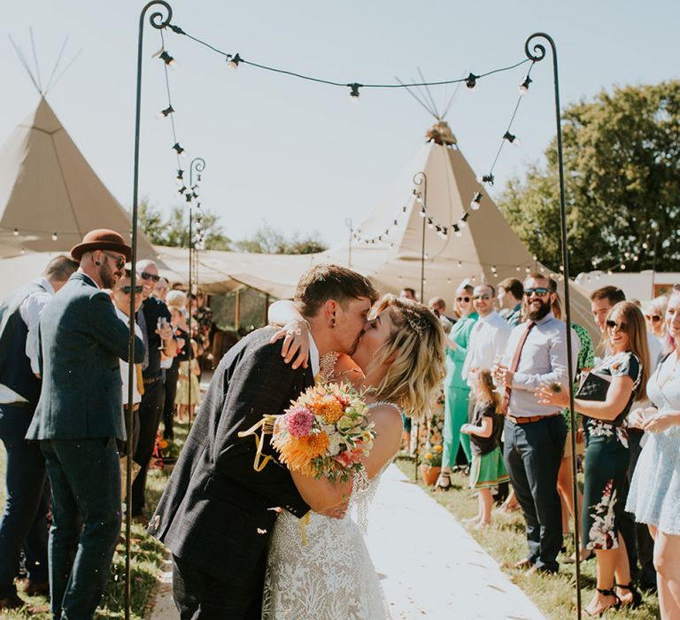 Bride and groom kiss after ceremony in PapaKata tipi