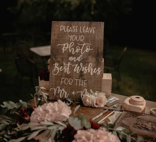 Polaroid Station with Wooden Sign and Floral Arrangement