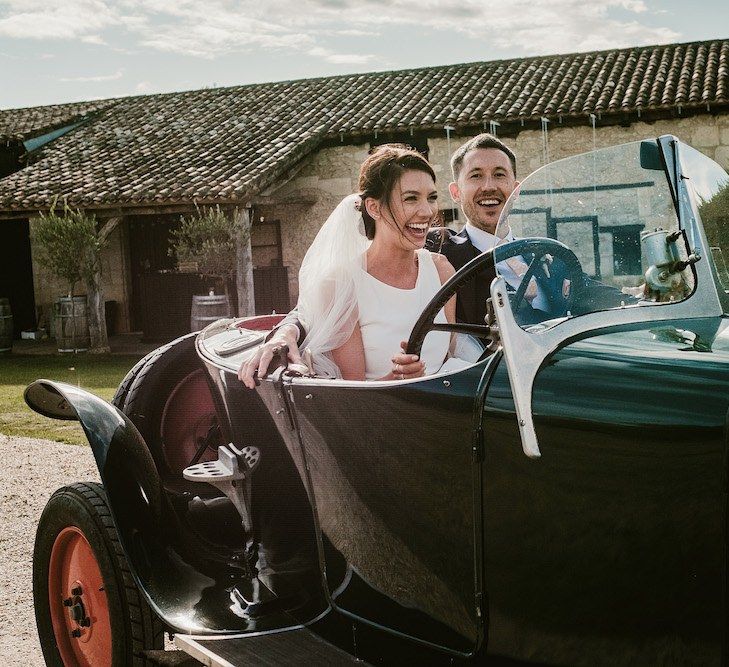 Bride and groom in vintage wedding car