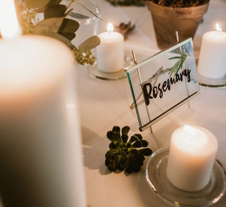 Candle lit tables with glass table name frames