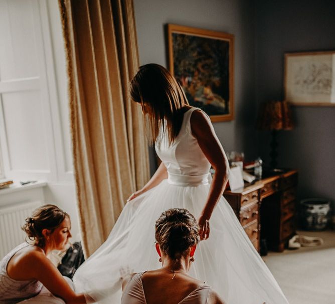 Bride getting ready in satin and tulle wedding dress