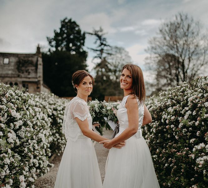 Lesbian wedding with two brides in chiffon and lace and satin and tulle bridal gowns