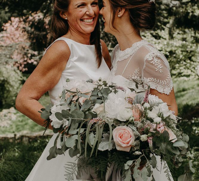 Lesbian wedding portrait with brides holding romantic bridal bouquets