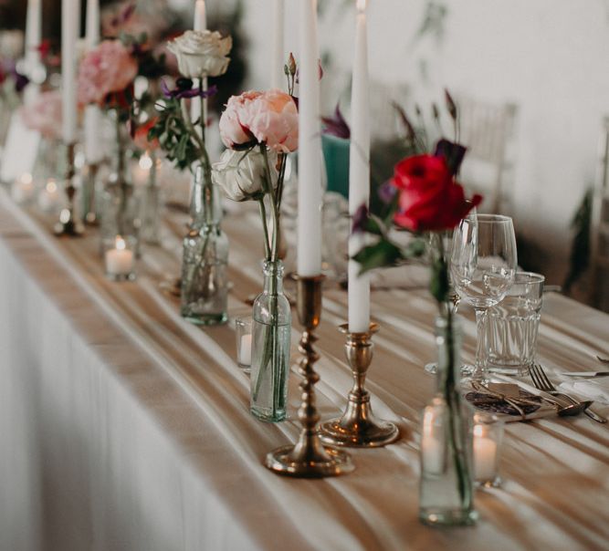 Top table  decor with taper candles and flower stems in vases