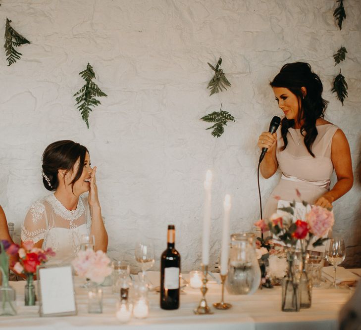 Bridesmaid in pink dress delivering wedding speech