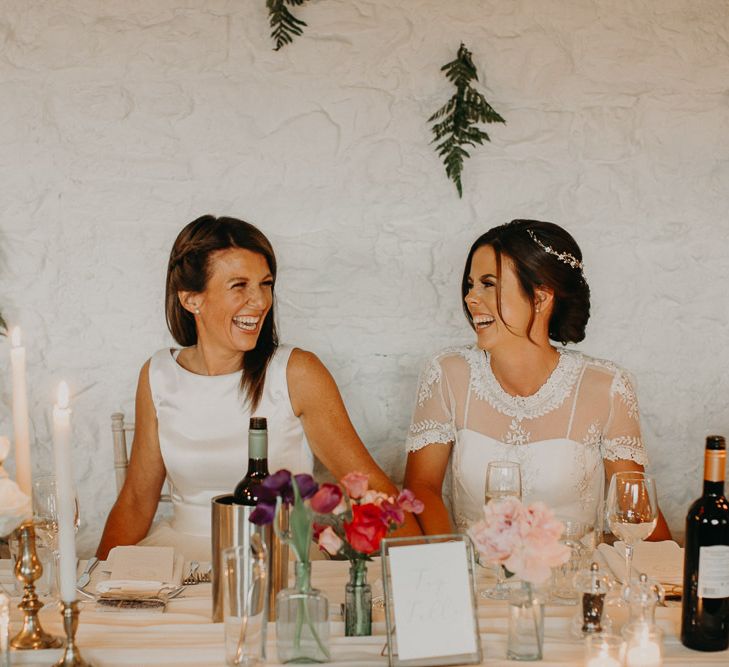 Two brides laughing at their same sex wedding reception