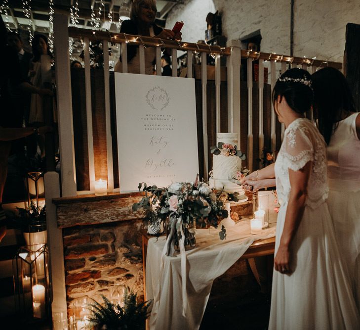 Two brides cutting the cake at their wedding