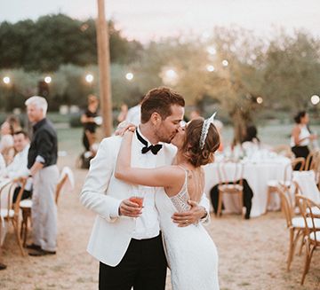 Bride and Groom Steal A Kiss During Outdoor Reception