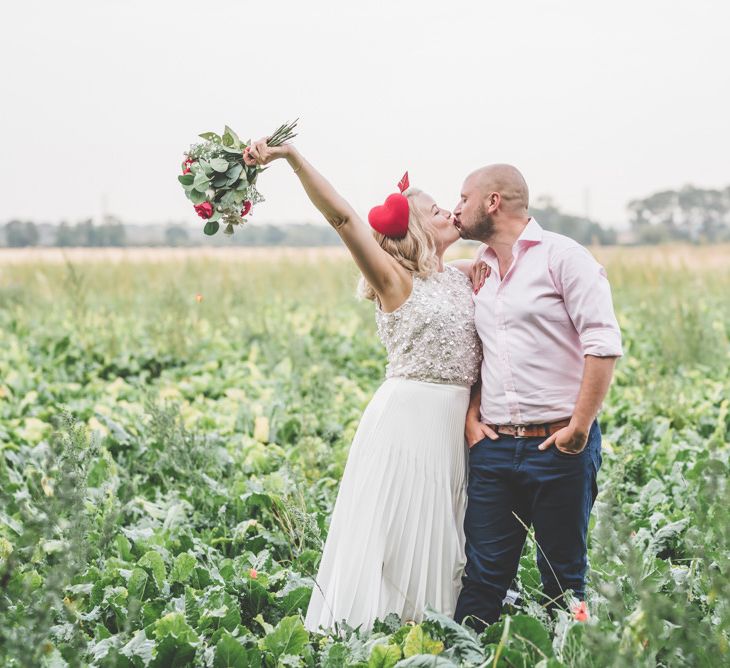 Bride and groom tie the knot with midi wedding skirt and bright heart hair decoration