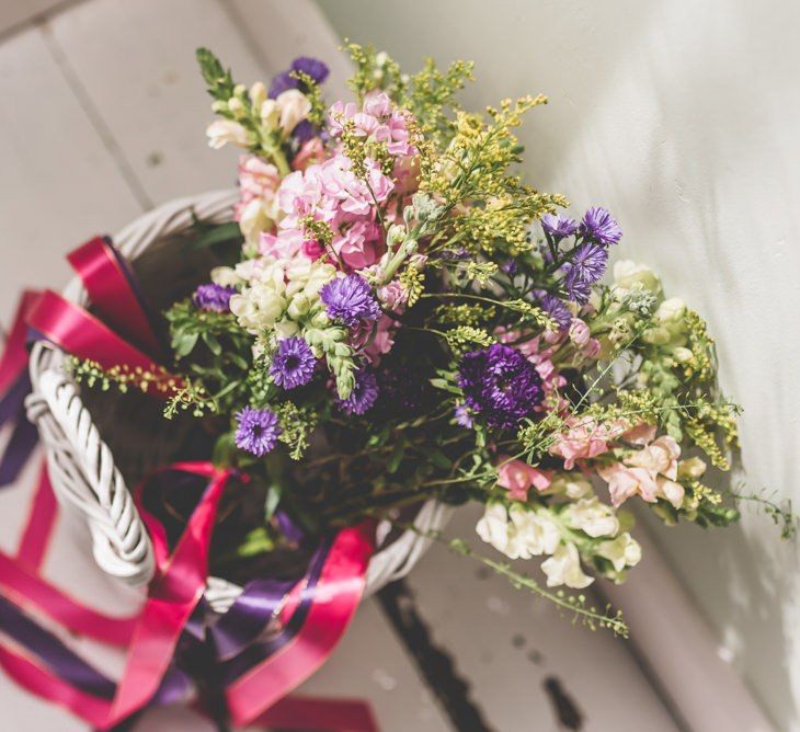 Pink and purple bridesmaid bouquets with matching ribbon decoration for fun fete themed celebration