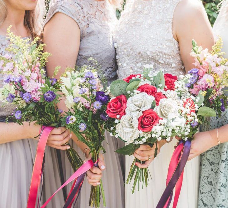 Floral bouquets with pink and purple ribbon detailing for village fete themed marquee celebration