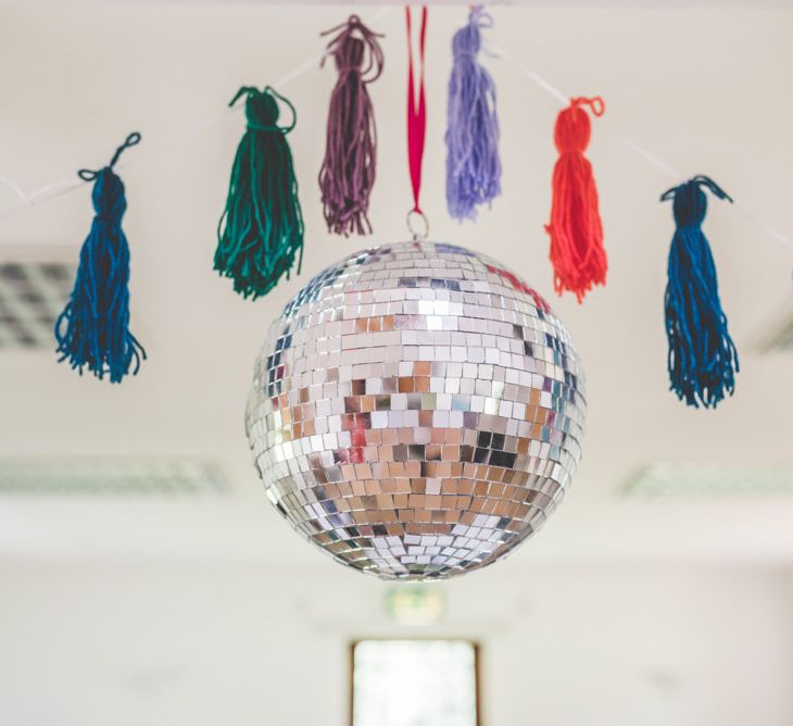 Homemade colourful tassels with glitter ball decorations at fun wedding reception