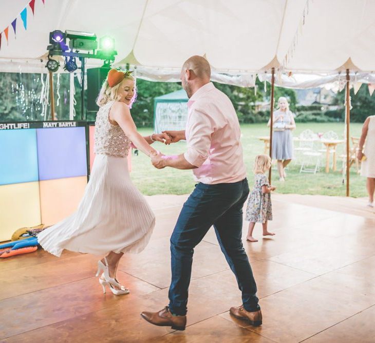 Bride and grooms first dance wearing midi wearing skirt with bight and colourful decor